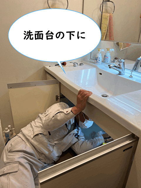 【画像】スタッフが洗面台の下に潜り込んで作業をしている様子です。